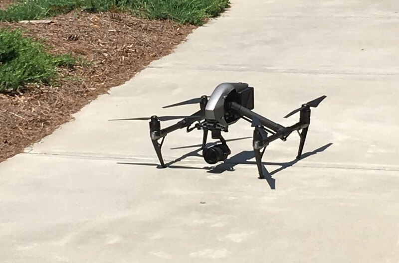 An aerial drone sits on a sidewalk