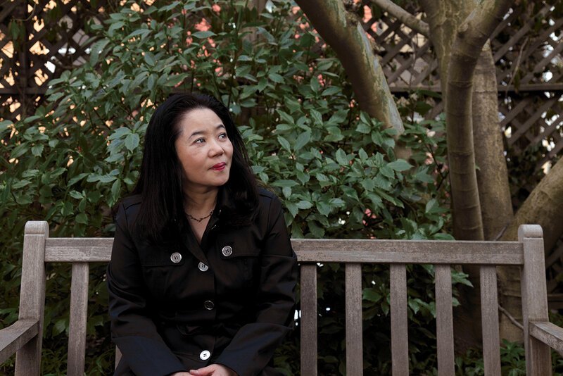 A portrait of Noriko Maeda seated on a bench