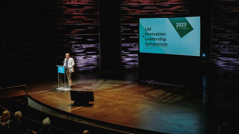 Roberto Rovira at a podium on a stage kicking off the 2023 symposium