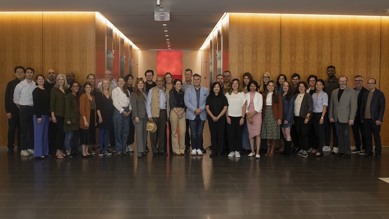 A group of 38 LAF Board members and staff stand posed in a hallway corridor